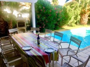 a table and chairs next to a swimming pool at La maison de Virginie in Saint Cyprien Plage