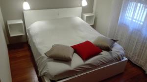 Una pequeña cama blanca con dos almohadas. en Camera Con Vista Este, en Este