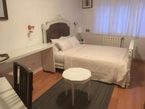 a bedroom with a bed and a table and a stool at Villa Cemaste in Montpellier