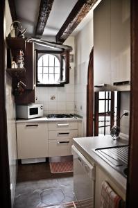 a kitchen with white cabinets and a stove top oven at Appartamento grazioso e centrale in Venice