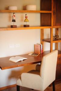 a wooden desk with a chair and a book at Casona Del Alto in San Martín de los Andes