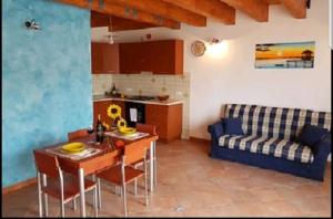 a kitchen and a living room with a table and a couch at Casa Vacanza Brigida in Scopello