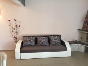 a couch with two pillows in a living room at Guest House Afrodita in Chernomorets