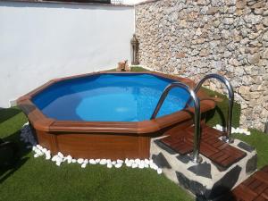 a hot tub in a yard with a stone wall at Casa Ayo in Frigiliana