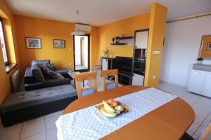 a kitchen and living room with a table with fruit on it at Apartment Sunny Place in Pula