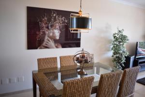 una sala da pranzo con tavolo in vetro e sedie di La Concha Vista La Quinta a Marbella
