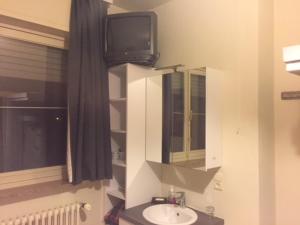 een badkamer met een wastafel en een tv aan de muur bij B&B House Caesekin in Diksmuide