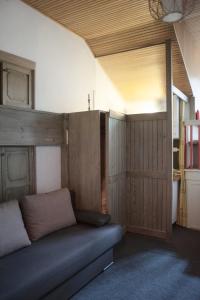 uma sala de estar com um sofá e uma parede de madeira em Apartment Carezza em Carezza al Lago