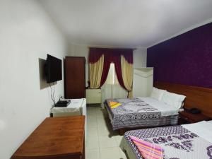 a hotel room with two beds and a television at Sun Hostel Cairo in Cairo