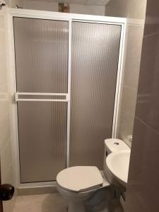 een badkamer met een douche, een toilet en een wastafel bij Hostal Rous San Gil in San Gil