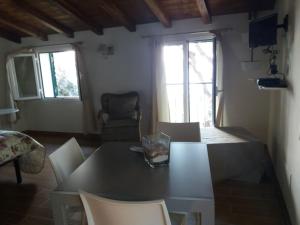 a living room with a table and chairs and two windows at La Torretta in Imperia