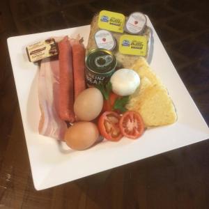 talerz jedzenia z jajkami kiełbasianymi i chlebem w obiekcie The Mouses House Rainforest Retreat w mieście Springbrook