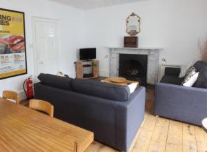 a living room with two couches and a fireplace at Drang house all rooms have stairs in Padstow