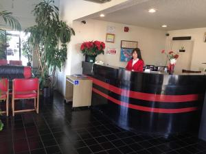 a woman standing at the counter of a restaurant at Grand Inn財神客棧 in Monterey Park