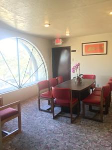 蒙特利公園的住宿－財神客棧大賓館，一间设有桌子和红色椅子的等候室