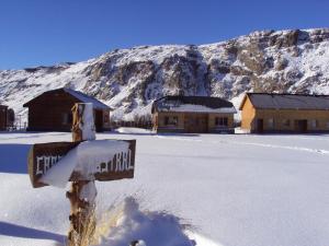 a cross in the snow in front of a mountain at Cabañas Austral in El Chalten