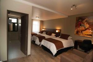 a hotel room with three beds and a couch at Hotel Manso de Velasco in San Fernando