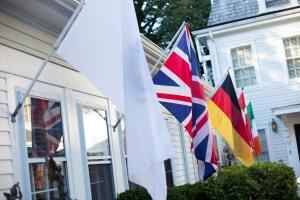 un grupo de banderas al lado de una casa en Old Manse Inn en Brewster