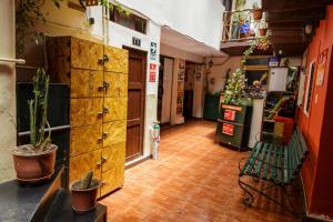 a room with a large wooden chest of drawers and plants at Ukukus Hostel in Cusco