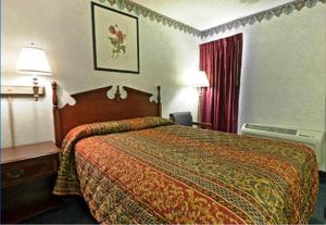 Habitación de hotel con cama y colcha roja en Americas Best Value Inn Anderson SC, en Anderson