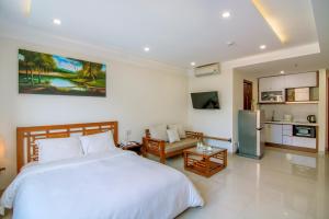 a bedroom with a large bed and a kitchen at Salamander Apartment hotel in Da Nang