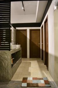 einen Flur eines Badezimmers mit einem Waschbecken und einer Tür in der Unterkunft Nirvana Guesthouse & Hostel in Ko Tao