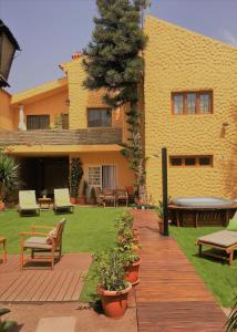 a house with a yard with benches and a lawn at Villa Strelitzia Gran Canaria in Ingenio
