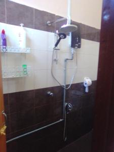 a shower with a shower head in a bathroom at D'Airport Homestay & Transit Rooms in Kota Bharu