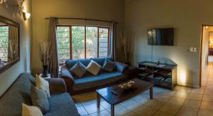 a living room with a couch and a coffee table at The Bush House in Hoedspruit