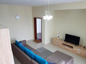 uma sala de estar com um sofá azul e uma televisão em Sugar Reef Apartment em Flic-en-Flac