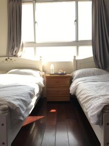 two beds in a room with a large window at manor in Houli