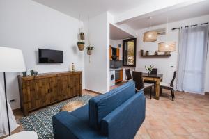 Una sala de estar con un sofá azul y una mesa. en LuminHouse Villa Mondello, en Mondello