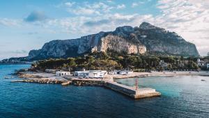 Una isla en el agua con una montaña al fondo en LuminHouse Villa Mondello, en Mondello