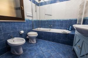 Un baño con azulejos azules, inodoro y lavabo. en LuminHouse Villa Mondello, en Mondello 45 fotos más