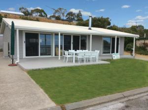 a house with a table and chairs in front of it at Millpond. in Penneshaw