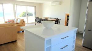 a kitchen with a white island in a living room at Millpond. in Penneshaw