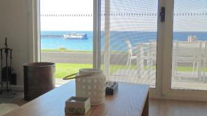 a room with a table with a view of the ocean at Millpond. in Penneshaw