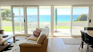 a living room with a couch and a view of the ocean at Millpond. in Penneshaw