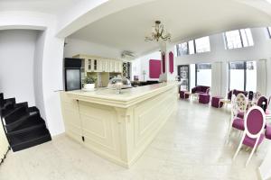 uma cozinha com cadeiras roxas e uma grande ilha de cozinha em Villa Boutique Lafayette em Bucareste