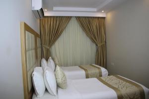 a hotel room with two beds and a air conditioner at AlMuhaidb Residence Alkhafji in Al Khafji