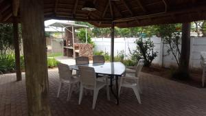 a table and chairs in a patio with an umbrella at Pretoria Inn in Pretoria