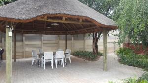 patio con tavolo e sedie sotto un tetto di Pretoria Inn a Pretoria