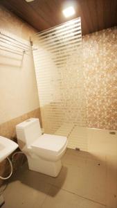 a bathroom with a white toilet and a shower at Kalappura Homestay in Alleppey