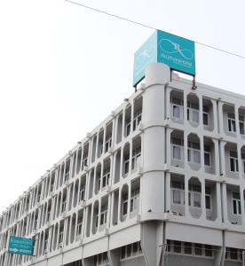 een wit gebouw met een bord erop bij Rajthani Hotel - SHA Certified in Suratthani