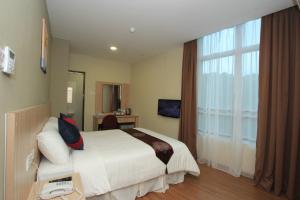 a hotel room with a bed and a window at Veer Hotel in Kuantan