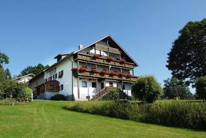 a large white house with balconies and a yard at Pension Draxlerhof in Neuschönau