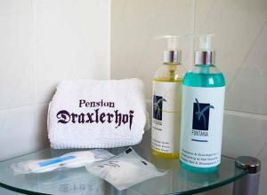 a glass table with two bottles of disinfectants and a towel at Pension Draxlerhof in Neuschönau