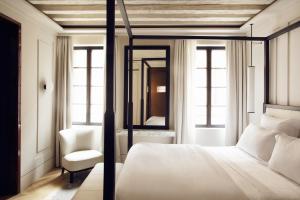 een slaapkamer met een bed, een stoel en een spiegel bij Palazzo Cristo in Venetië