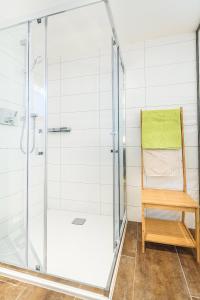 ducha con puerta de cristal y silla de madera en Appartement Heidi, en Umhausen 16 fotos más
