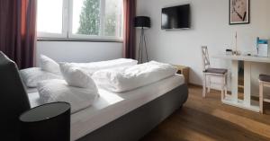 リンダウにあるFreches Wohnen - Apartmentの白い枕が付いたベッドが備わる客室です。